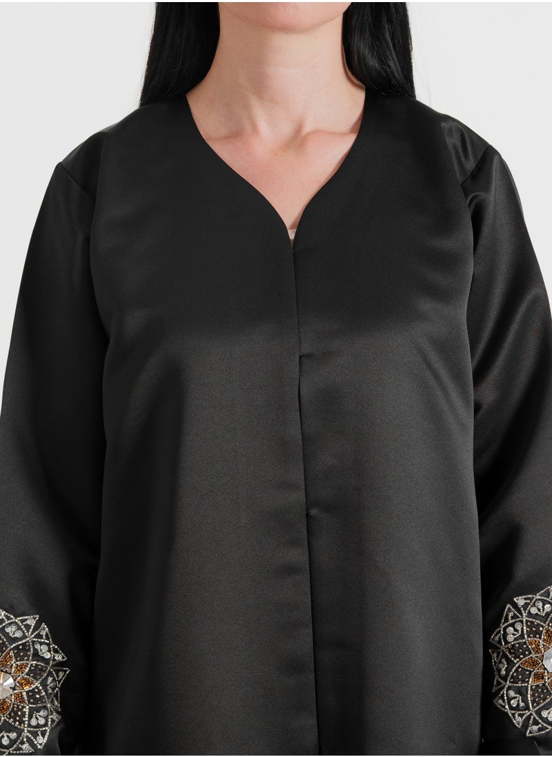 A luxurious abaya featuring silver Arabic-inspired hand embroidery