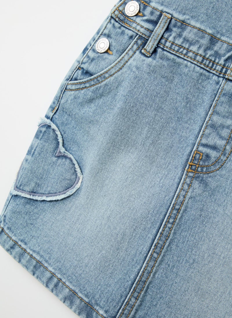Pinafore in denim with heart embroidery