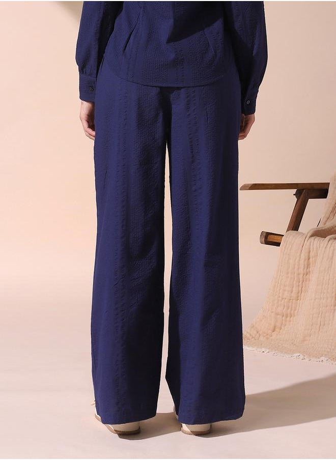 Women blue loose fit solid cotton blend trousers with button closure- where comfort meets classic charm.