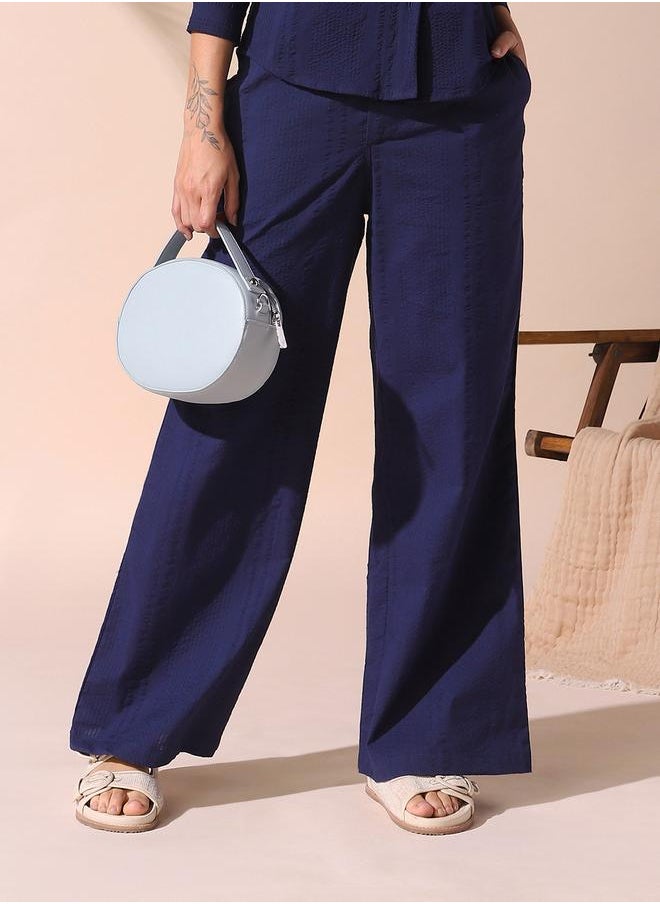 Women blue loose fit solid cotton blend trousers with button closure- where comfort meets classic charm.