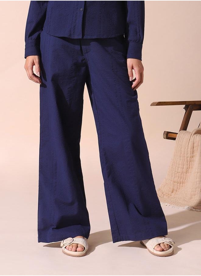 Women blue loose fit solid cotton blend trousers with button closure- where comfort meets classic charm.