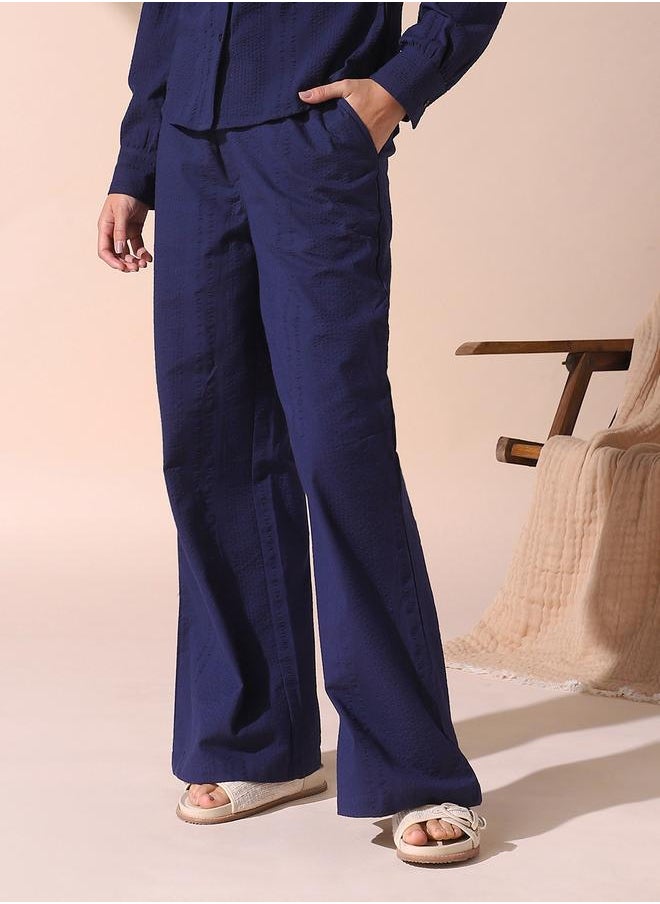 Women blue loose fit solid cotton blend trousers with button closure- where comfort meets classic charm.