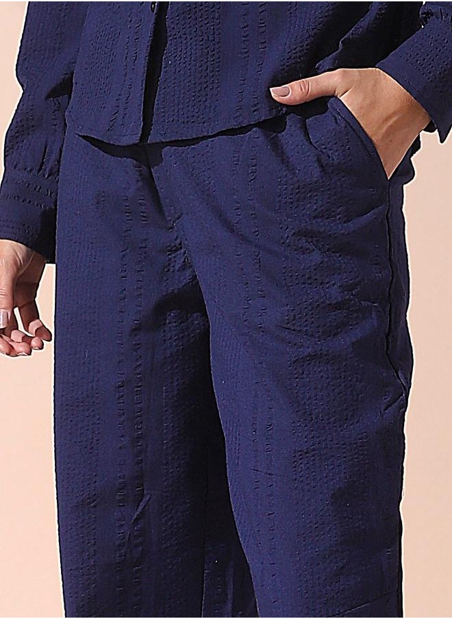 Women blue loose fit solid cotton blend trousers with button closure- where comfort meets classic charm.