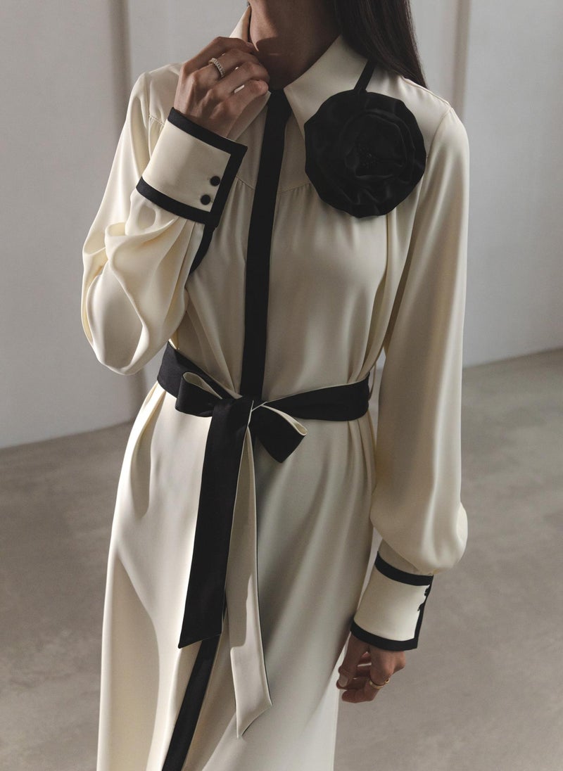 Maxi dress with contrasting inserts and flower brooch